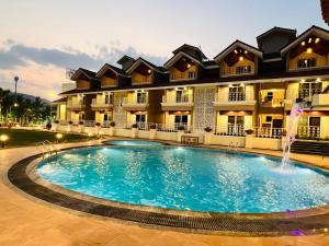 a swimming pool in front of a building at The Grand Leela Resort in Khopoli