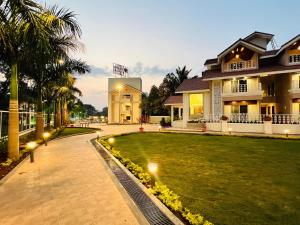 a lawn in front of a house with lights at The Grand Leela Resort in Khopoli