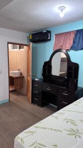 1 dormitorio con tocador con espejo y lavamanos en The Wave Hostel Corn Island, en Corn Island