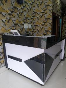 a reception desk in front of a wooden wall at Hotel Ambika in Deoghar