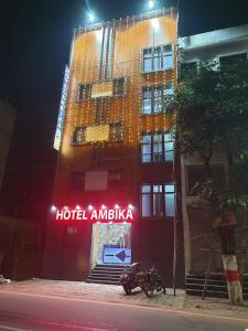 un bâtiment avec un insigne d'hôtel devant lui dans l'établissement Hotel Ambika, à Deoghar