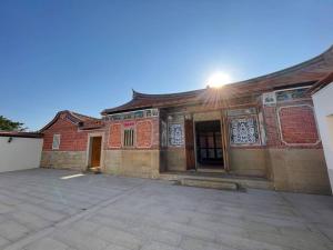 an old brick building with a courtyard in front of it at Sunshine Music Traditional Guesthouse in Jinsha