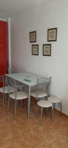 a table and chairs in a room with a white wall at Carboneras, maravillate de su paraiso natural in Carboneras