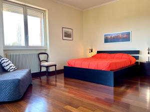 1 dormitorio con 1 cama roja y 1 silla en Torrenova 22 en Roma