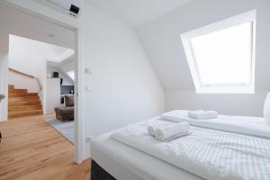 a white bedroom with a bed and a window at SYMPHONY Apartments 39 - Modern Loft with Terrace and Grill in Central Location in Vienna