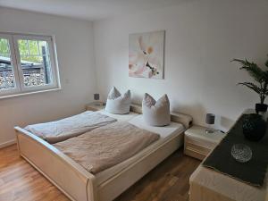 Schlafzimmer mit einem Bett mit weißer Bettwäsche und Kissen in der Unterkunft Ferienwohnung Königsberg in Bad König