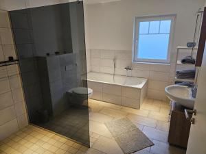ein Badezimmer mit einer Badewanne, einem WC und einem Waschbecken in der Unterkunft Ferienwohnung Königsberg in Bad König