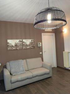 sala de estar con sofá y lámpara de araña en Xenia di Giò - Appartamento con giardino en Caravaggio