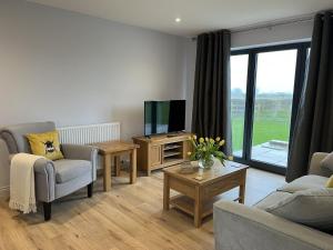 a living room with a couch and a tv at Fleetwood 2 bed cottage in Tunstall