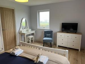 a bedroom with a bed and a tv and a mirror at Fleetwood 2 bed cottage in Tunstall