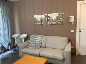 a living room with a couch and two paintings on the wall at Xenia di Giò - Appartamento con giardino in Caravaggio