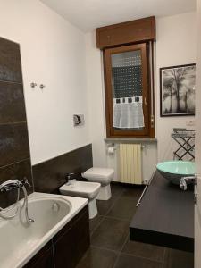 a bathroom with a sink and a toilet and a tub at Xenia di Giò - Appartamento con giardino in Caravaggio