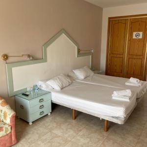 a bedroom with a bed and a dresser and a door at Hotel Algorfa in Castillo de Montemar