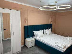 a bedroom with a large bed with a blue headboard at Гостиница in Taraz