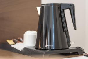 Lesvion Hotel في ميتيليني: وجود وعاء قهوة أسود على طاولة