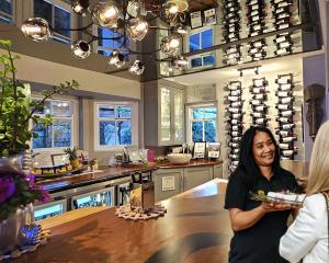 a woman standing in a wine tasting room with a woman at Fleur du Soleil Luxury Guesthouse in Franschhoek