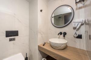 bagno con lavandino e specchio di Lesvion Hotel a Mytilini