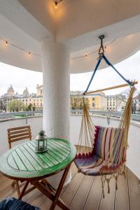 uma rede de descanso, uma mesa e uma cadeira num alpendre em Cool Opera Apartments em Cluj-Napoca