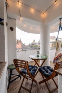 um pátio com 2 cadeiras e uma mesa na varanda em Cool Opera Apartments em Cluj-Napoca