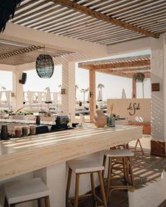 a kitchen with a wooden counter and stools at Le Sidi Cabanas Hacienda Bay in El Alamein