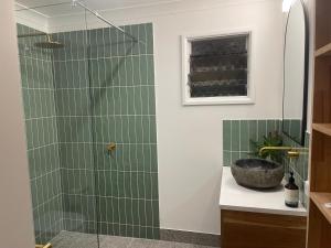 a bathroom with a shower with green tiles at The Treehouse at Alma Bay in Arcadia