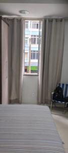 1 dormitorio con cama y ventana en Cantinho bom para curti o mar, en Río de Janeiro