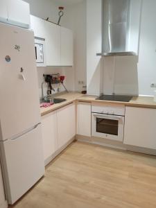 a kitchen with white cabinets and a white refrigerator at Apartamento El Cachorro de Triana in Seville