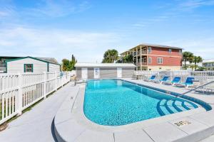 a swimming pool with chairs next to a building at Misty Harbour 7 in Panama City Beach +23 photos