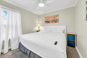 a bedroom with a large white bed and a window at Misty Harbour 7 in Panama City Beach