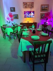 una sala da pranzo con tavoli e sedie con tavoli verdi di Hotel Soleo a Quartu SantʼElena