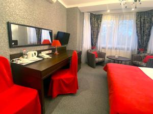a hotel room with a bed and a desk and chairs at Apartment Eney in Lviv