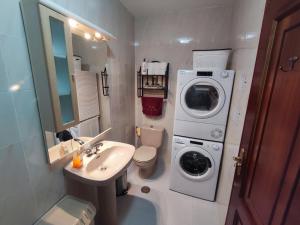 a small bathroom with a washing machine and a sink at Amplio Apartamento con terraza a 150 m playa in Porto do Son