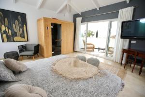 um quarto com uma cama com uma televisão e uma sala de estar em Sapore di mare Luxury B&B and Cooking em Marbella
