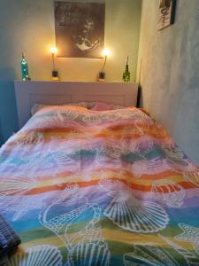 a bed with a colorful comforter in a bedroom at Studio-Apartment mit kleinem Gartenanteil in Burg auf Fehmarn