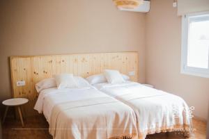 dwa łóżka siedzące obok siebie w sypialni w obiekcie HOSTAL ENTREOLIVOS w mieście Badajoz