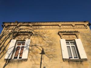 zwei Fenster an der Seite eines Gebäudes in der Unterkunft Le Numéro 15 in Saint-Seurin-sur-lʼIsle