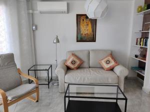ein Wohnzimmer mit einem Sofa und 2 Stühlen in der Unterkunft Algarrobo Costa luxury apartment POMELO , seafront in Algarrobo-Costa