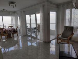 - un salon avec des chaises, une table et des portes en verre dans l'établissement Algarrobo Costa luxury apartment POMELO , seafront, à Algarrobo-Costa