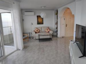 - un salon avec un canapé et une télévision dans l'établissement Algarrobo Costa luxury apartment POMELO , seafront, à Algarrobo-Costa