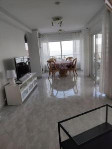 ein großes Wohnzimmer mit einem Tisch und Stühlen in der Unterkunft Algarrobo Costa luxury apartment POMELO , seafront in Algarrobo-Costa