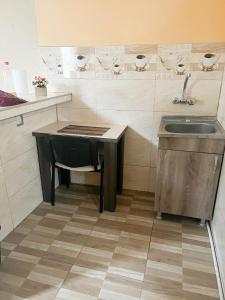 a kitchen with a sink and a table with a chair at Hotel Villa in Tbilisi City