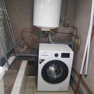 una lavadora en una habitación con un depósito de agua en marie-Emma wifi gratuite, en Beaulieu-sur-Loire