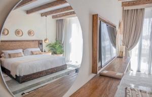 ein Schlafzimmer mit einem großen Bett und einem Spiegel in der Unterkunft Le Sidi Cabanas Hacienda Bay in El-Alamein