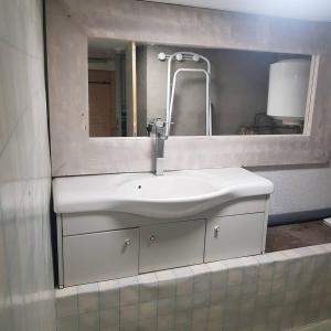 a bathroom with a white sink and a mirror at marie-Emma wifi gratuite in Beaulieu-sur-Loire