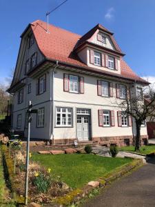 a large white house with a red roof at Ferienwohnung am Stockerbach in Freudenstadt