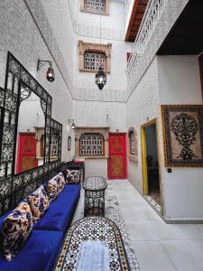 Zimmer mit blauem Sofa und Kissen in der Unterkunft Riad Najiba in Rabat