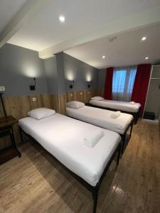 um quarto com três camas num quarto em Hotel Old Quarter em Amsterdã