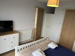 a small bedroom with a bed and a tv at Genesis 1 bed cottage in Tunstall