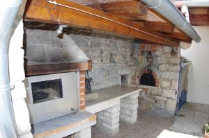 un forno in pietra in una stanza con muro di mattoni di Tolles Ferienhaus in Peresiji mit Privatem Pool a Peresiji