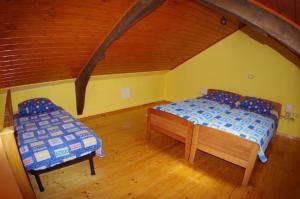 una camera da letto con due letti e una sedia in mansarda di Tolles Ferienhaus in Peresiji mit Privatem Pool a Peresiji